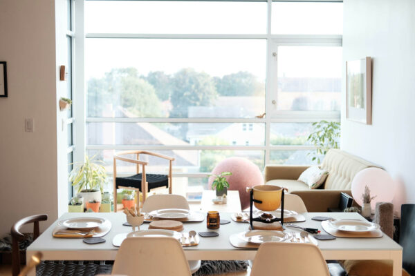 Living space with elegant dining table set for fondue and large window.