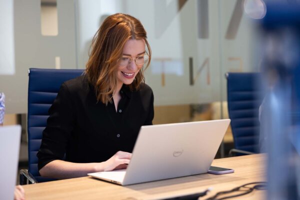 Avanti employee working on laptop computer during meeting.