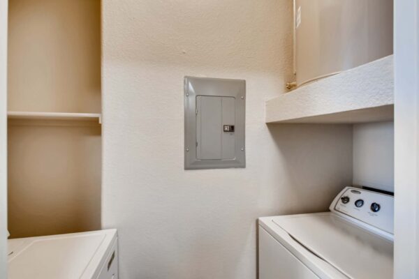 Mandarina apartment laundry room with washer, dryer, and breaker panel.