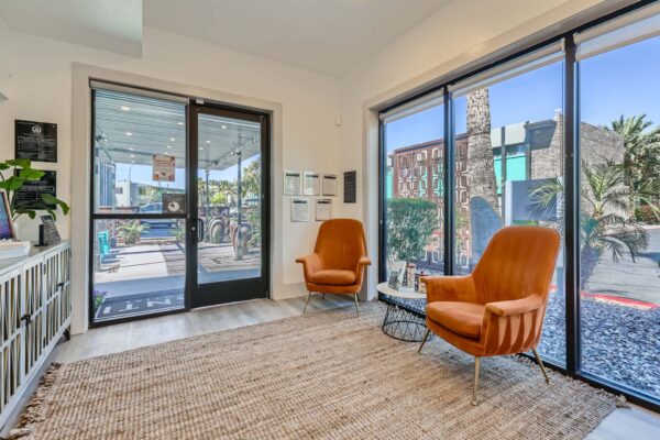 Omnia on Thomas apartments lobby with plush orange armchairs and large windows.