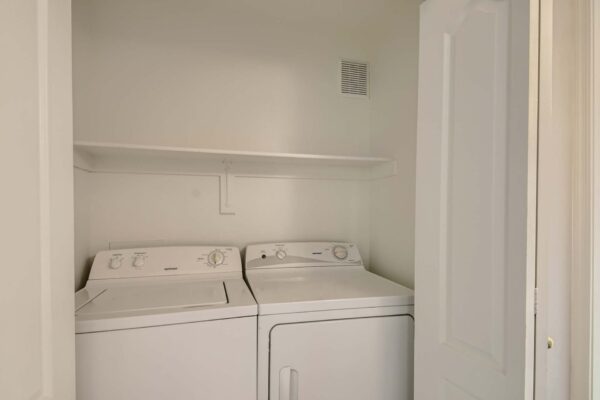 Springs at Alta Mesa apartment laundry closet with washer, dryer, and built in shelf.