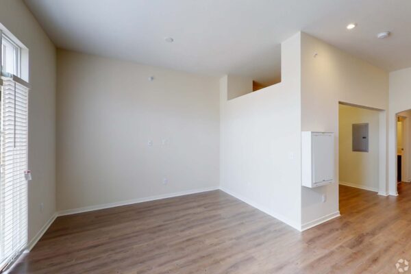 The Locale apartment living area with wood style floor and balcony doors.