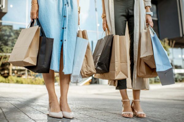 Two friends shopping together with shopping bags.