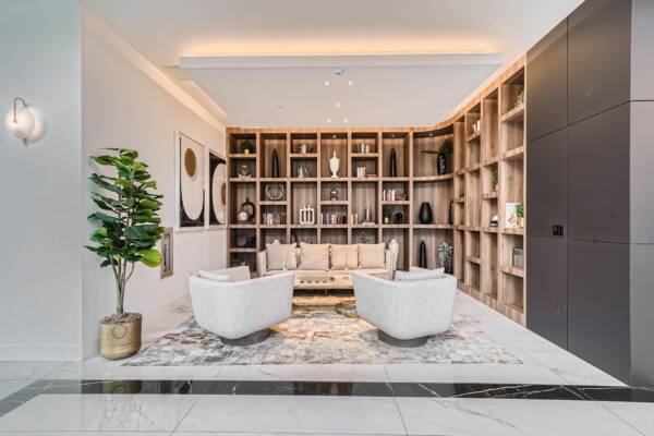 Arte Grand Central apartments resident lounge with plush seating and shelves with decor.