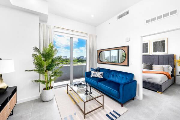 Living room at Arte Grand Central with balcony and bedroom door.
