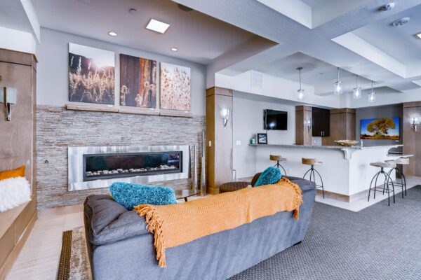 Centre Court apartments clubroom with community kitchen, fireplace, and plush seating.