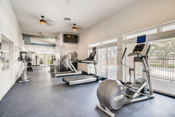 Copper Ridge apartments fitness center with cardio machines and large windows.