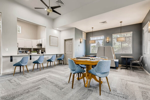 Copper Ridge apartments clubroom with game table, community kitchen, and cozy booths.
