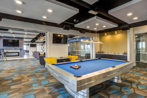 Forum Fitzsimons apartments lounge with pool table and arcade game.