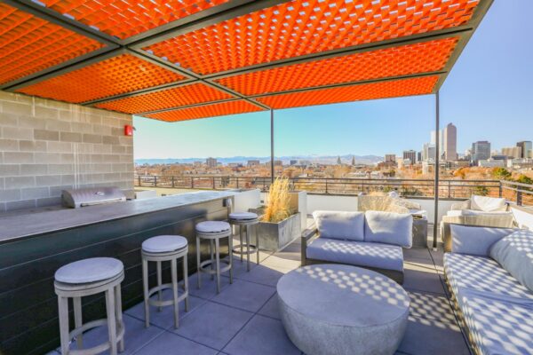 The Economist apartments rooftop deck with outdoor seating, BBQ grill, and gazebo.