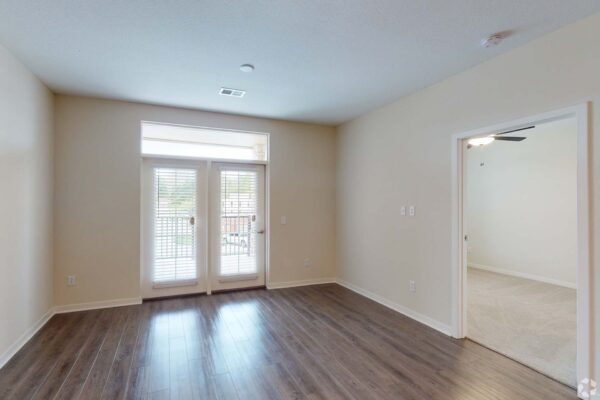 The Locale apartment living room with wood style floor and balcony door.