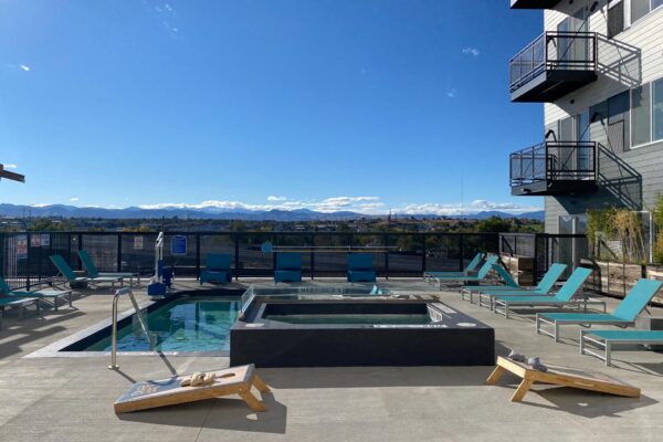 The Overland apartments rooftop deck with hot tub, corn hole game, and lounge chairs.