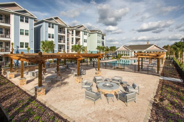 The Point at Bella Grove apartments outdoor lounge area with firepit, grilling stations next to pool area.