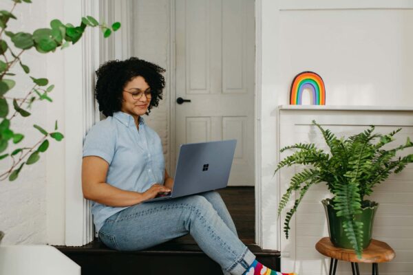 Person using resident portal on laptop computer in apartment.