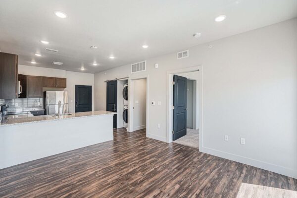 The Marc at Monument Ridge apartment living area with wood floors and cool gray walls.