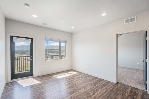 The Marc at Monument Ridge apartment living area with wood floors and cool gray walls.