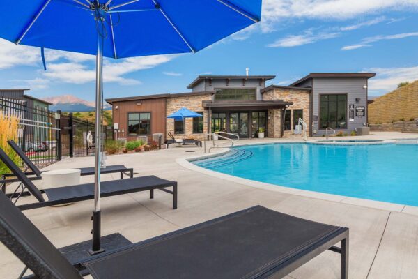 The Preserve at Mesa Creek pool area with lounge chairs and umbrellas.