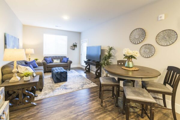 The Retreat at Patriot Park apartment living area with plush seating, elegant decor, and dining area.
