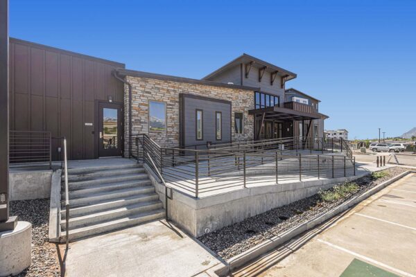 The Preserve at Mesa Creek entrance with rocky landscaping, ample parking, and modern architecture.