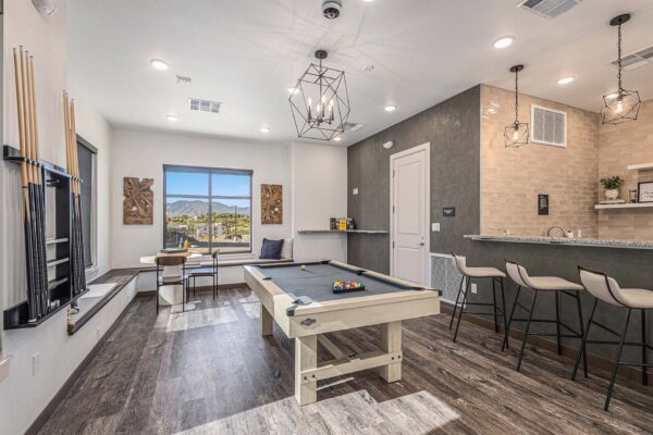 The Preserve at Mesa Creek game room with pool table, community bar, and large windows.