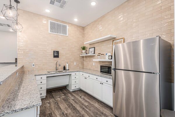 The Preserve at Mesa Creek community bar with wood style floor, stone counters, and stainless steel appliances.