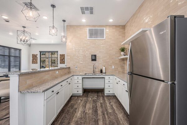 The Preserve at Mesa Creek community bar with wood style floor, white cabinets, and stone counters.