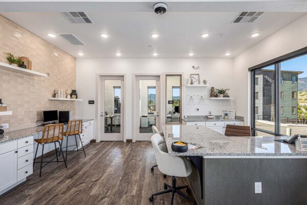 The Preserve at Mesa Creek leasing office with stone desk, chairs, and computers.