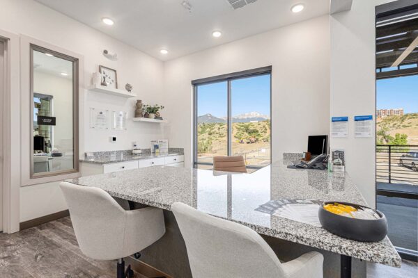 The Preserve at Mesa Creek reception desk with stone counter, chairs, and large windows.