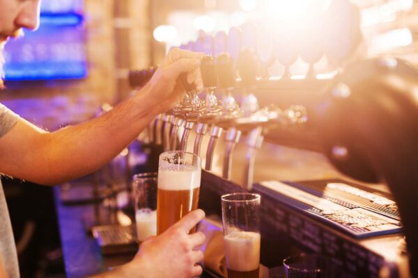 Person pouring beer from tap at brewery.
